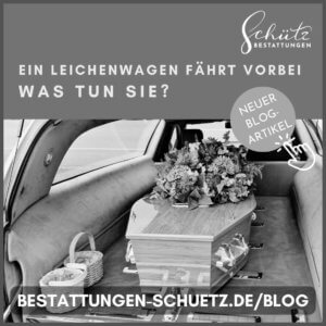 Schwarz-weiß Bild: Oben links ein Logo mit dem Schriftzug 'Schütz Bestattungen' und der Frage 'Ein Leichenwagen fährt vorbei. Was tun Sie?'. Darunter ein edler Holzsarg mit Blumenbukett in einem Leichenwagen, fotografiert von hinten durch die offene Heckklappe. Links zwei Körbe für Blütenblätter, unten der Schriftzug 'bestattungen-schuetz.de/blog'. Rechts ein Kreis mit 'Neuer Blog Artikel' und eine stilisierte Hand, die darauf zeigt.